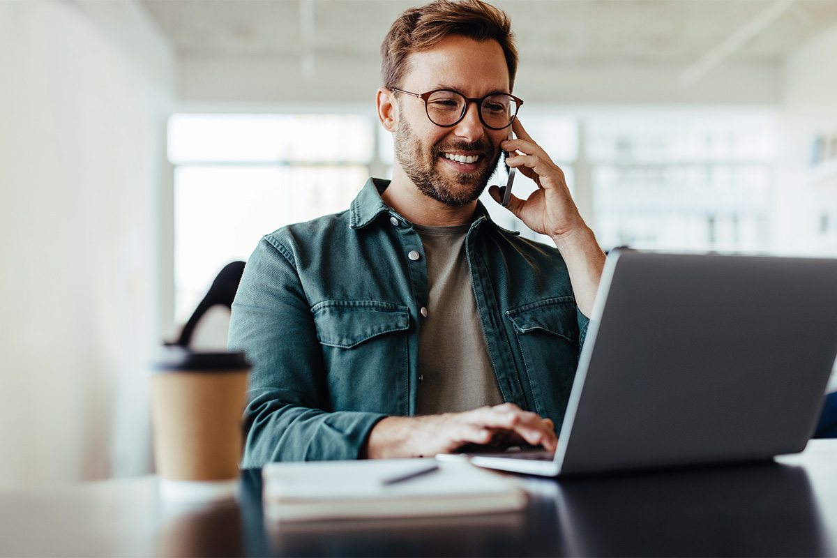 Startet mit Smart Upgrade – persönliche Beratung am Telefon oder digital Mann telefoniert am Laptop – Smart Upgrade berät euch zur Arbeitssicherheit und Gefährdungsbeurteilung